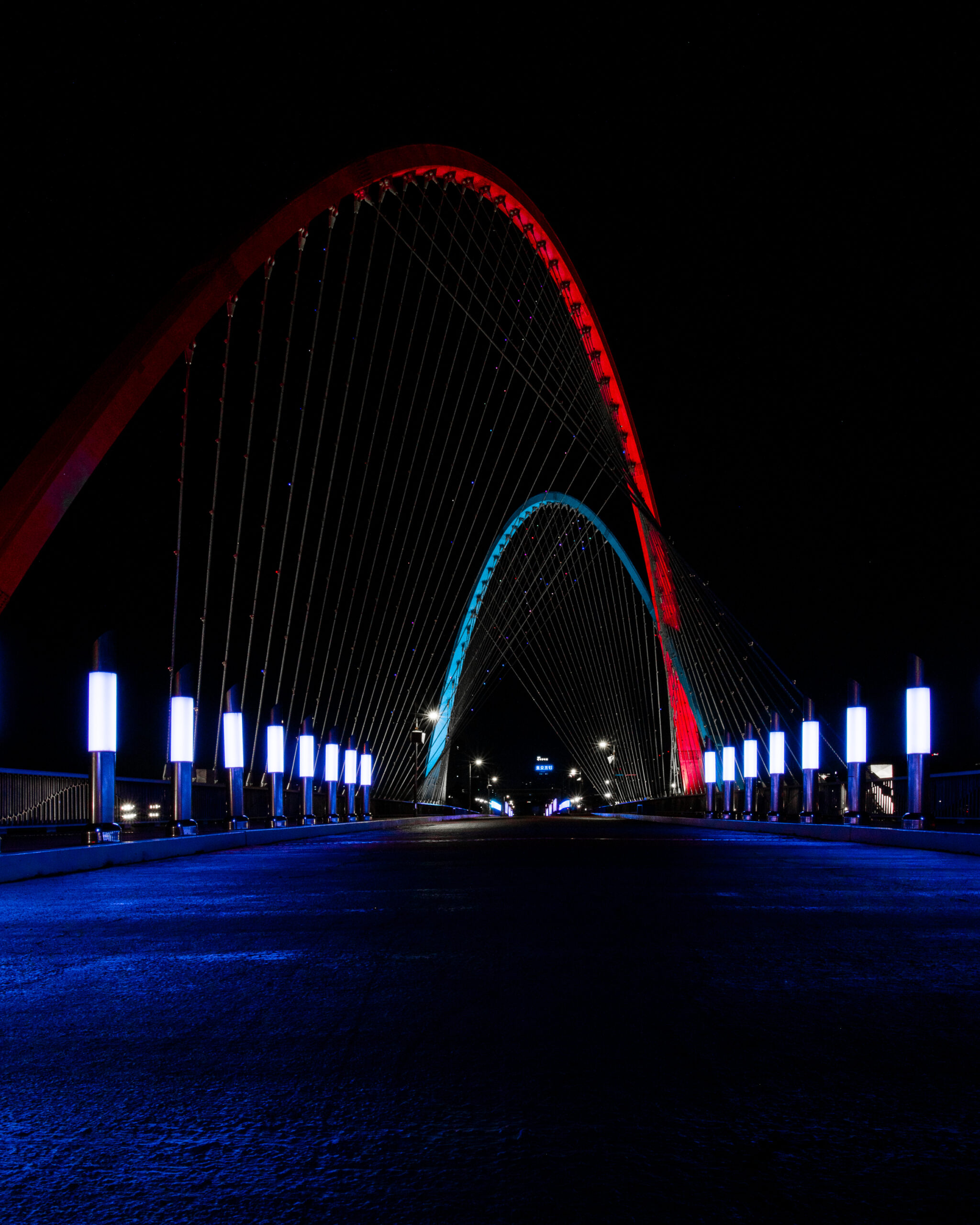 Wide Angle long exposure of Daejeon Expo Bridge with its Red and Blue modern cross braces lined by violet light pillar.